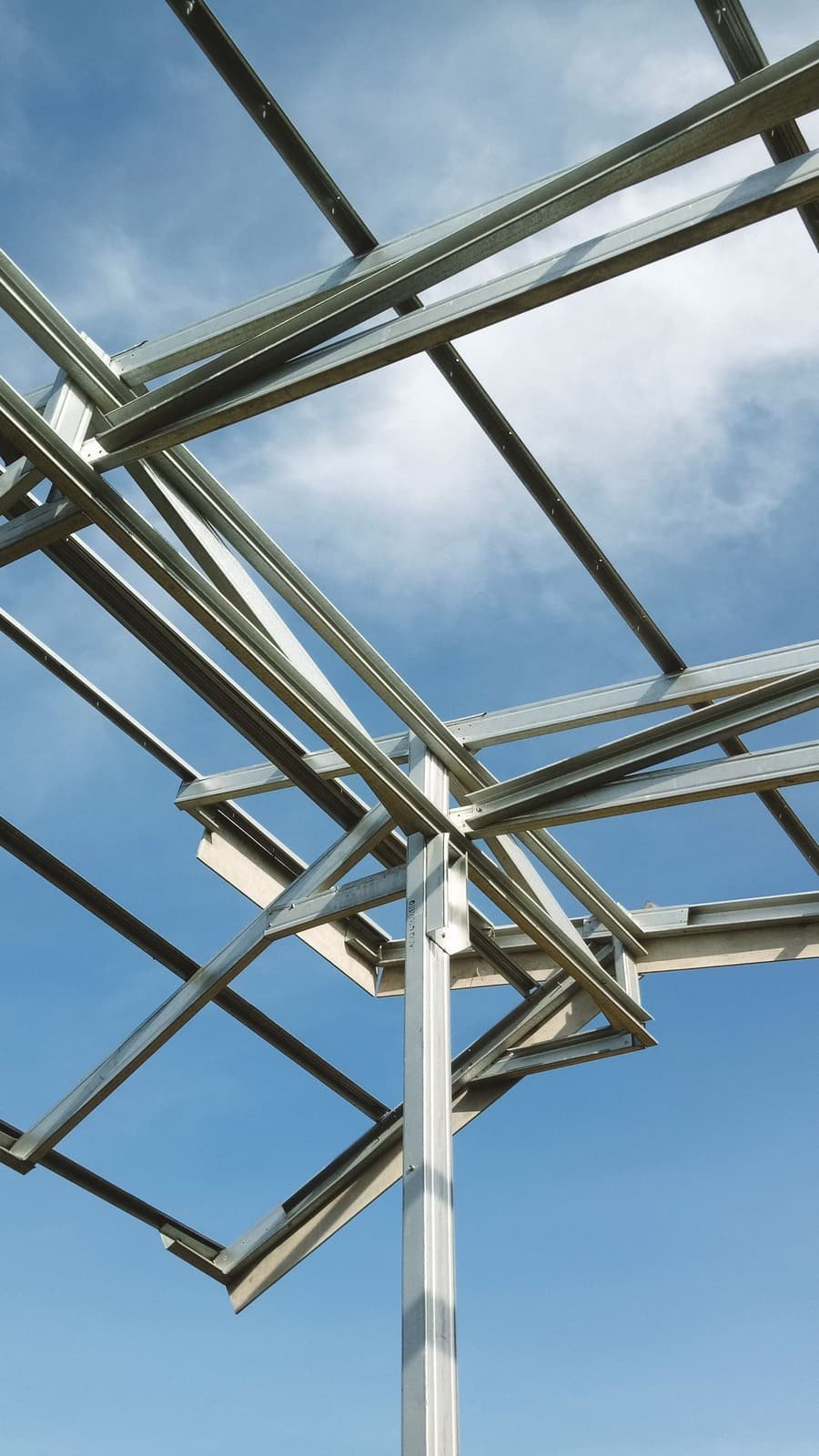 Estructura metálica de acero para techumbre en construcción contra cielo azul
