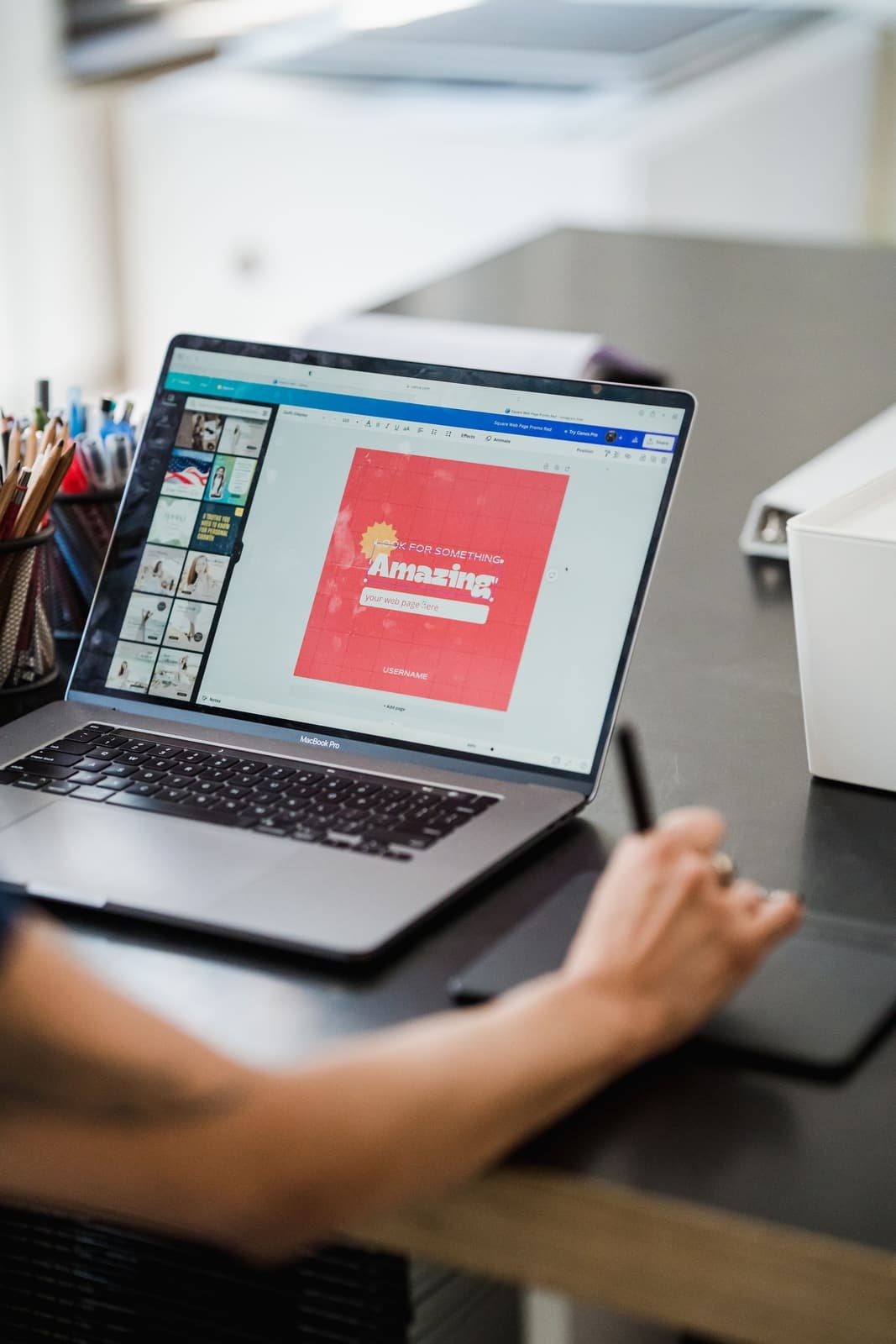 Manos de un diseñador trabajando un sitio web con tableta gráfica y laptop