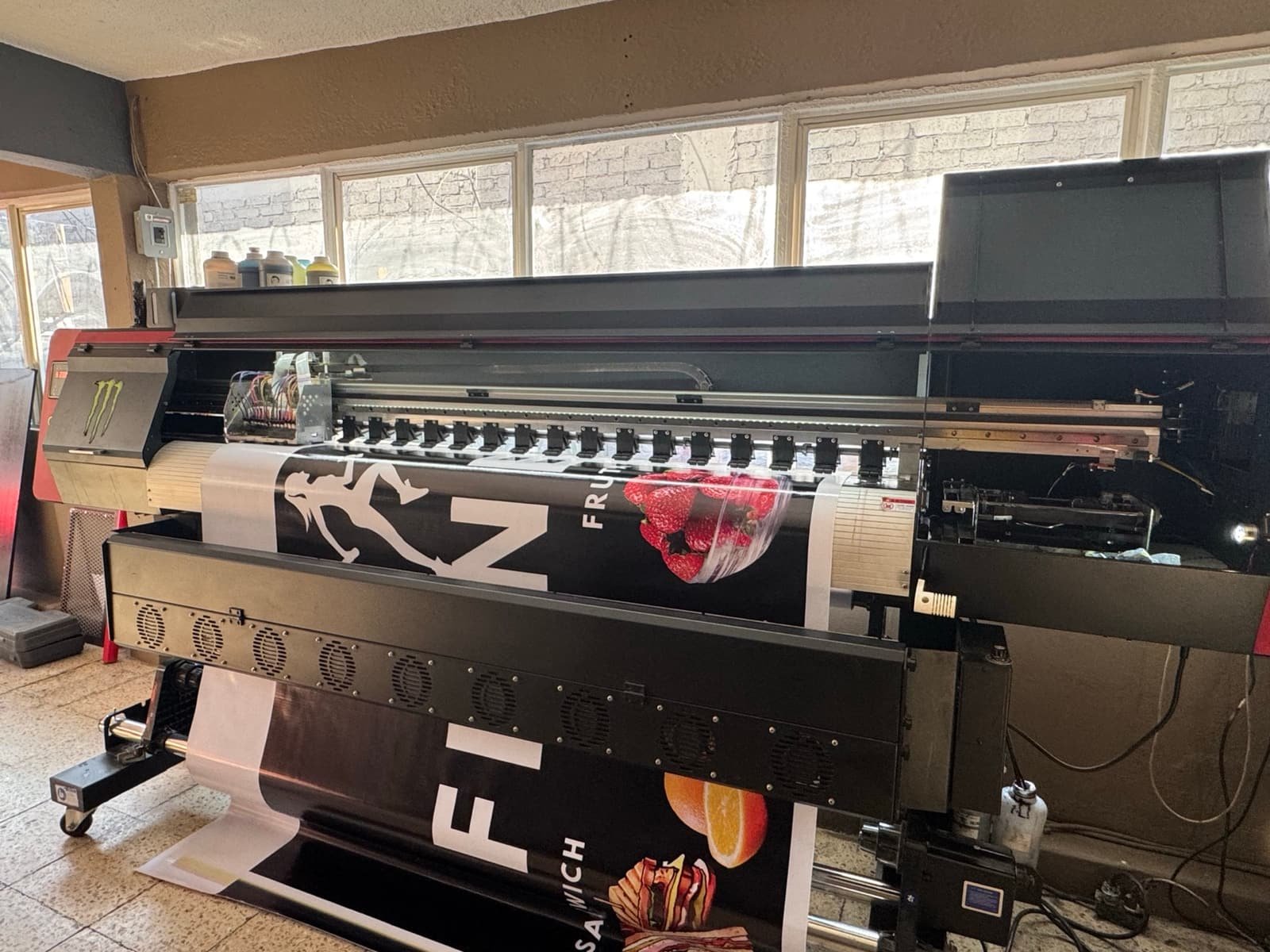 Lona publicitaria imprimiéndose en el plotter de gran formato de la planta